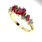 An angled view of the 18ct yellow gold ring highlighting the light interaction with the rubies and diamonds.