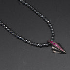 Front view of the silver Art Deco necklace featuring pave set rubies and faceted hematite gemstone beads.