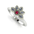 Angled view of a ruby and marquise diamond cluster engagement ring in a polished white metal setting.