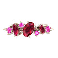 Front-facing view of the 18ct rose gold Atlantis Paradise ring featuring an asymmetrical cluster of vibrant red rubies and a pink sapphire.