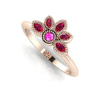 Angled perspective of a ruby and pink sapphire cluster ring in 18ct rose gold with fine milgrain textured edges.