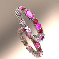 A three-quarter studio view of the Fire eternity ring in white gold, showing the alternating marquise-cut pink sapphires and brilliant-cut rubies in their claw settings.
