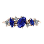 Front-facing view of the 9ct rose gold Atlantis Paradise ring featuring a central blue sapphire and two asymmetrical diamonds.