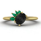Selene black diamond and emerald engagement ring in 18ct yellow gold front view showing pear emerald cluster setting