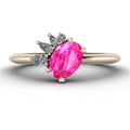 Selene cluster engagement ring, showcasing a vibrant oval pink sapphire nestled within an asymmetric arrangement of white diamonds on a rose gold band.