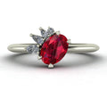 Selene oval ruby and diamond engagement ring in 18ct white gold front view showing asymmetric pear and round diamond cluster