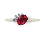 Selene oval ruby and diamond engagement ring in 18ct white gold top-down view showing vivid red ruby and asymmetric pear diamond cluster