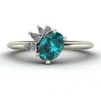 Selene oval teal sapphire and diamond asymmetric cluster engagement ring in 18ct white gold or platinum, front view showing the vivid teal sapphire and asymmetric pear and round diamond cluster, handmade in our London studio