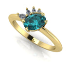 Selene oval teal sapphire and diamond engagement ring in 18ct yellow gold three-quarter view showing diamond cluster detail and polished band