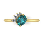 Selene oval teal sapphire and diamond engagement ring in 18ct yellow gold top-down view showing vivid teal sapphire and asymmetric pear diamond cluster