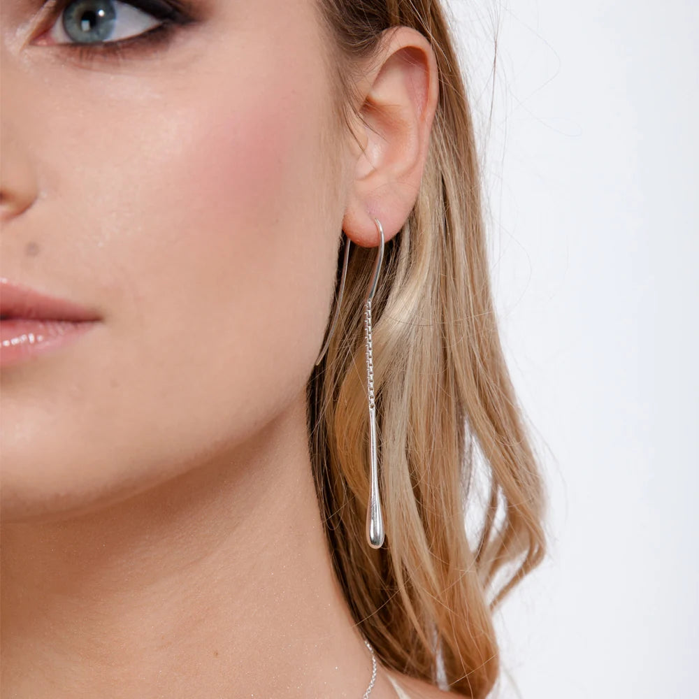 Silver Drop Earrings in sterling silver — model close-up showing chain threader and polished droplet worn in ear