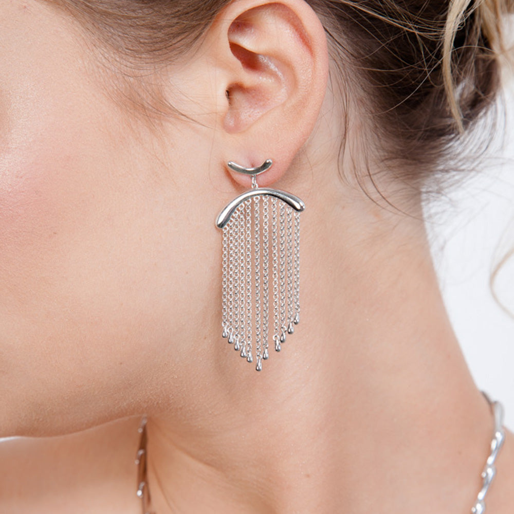 Model view of handmade silver falling earrings showing the movement of the chain and droplets.