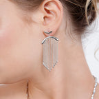 Silver Falling Earring worn on a model’s left ear, showing cascading droplet-tipped chains suspended beneath a polished silver arch.