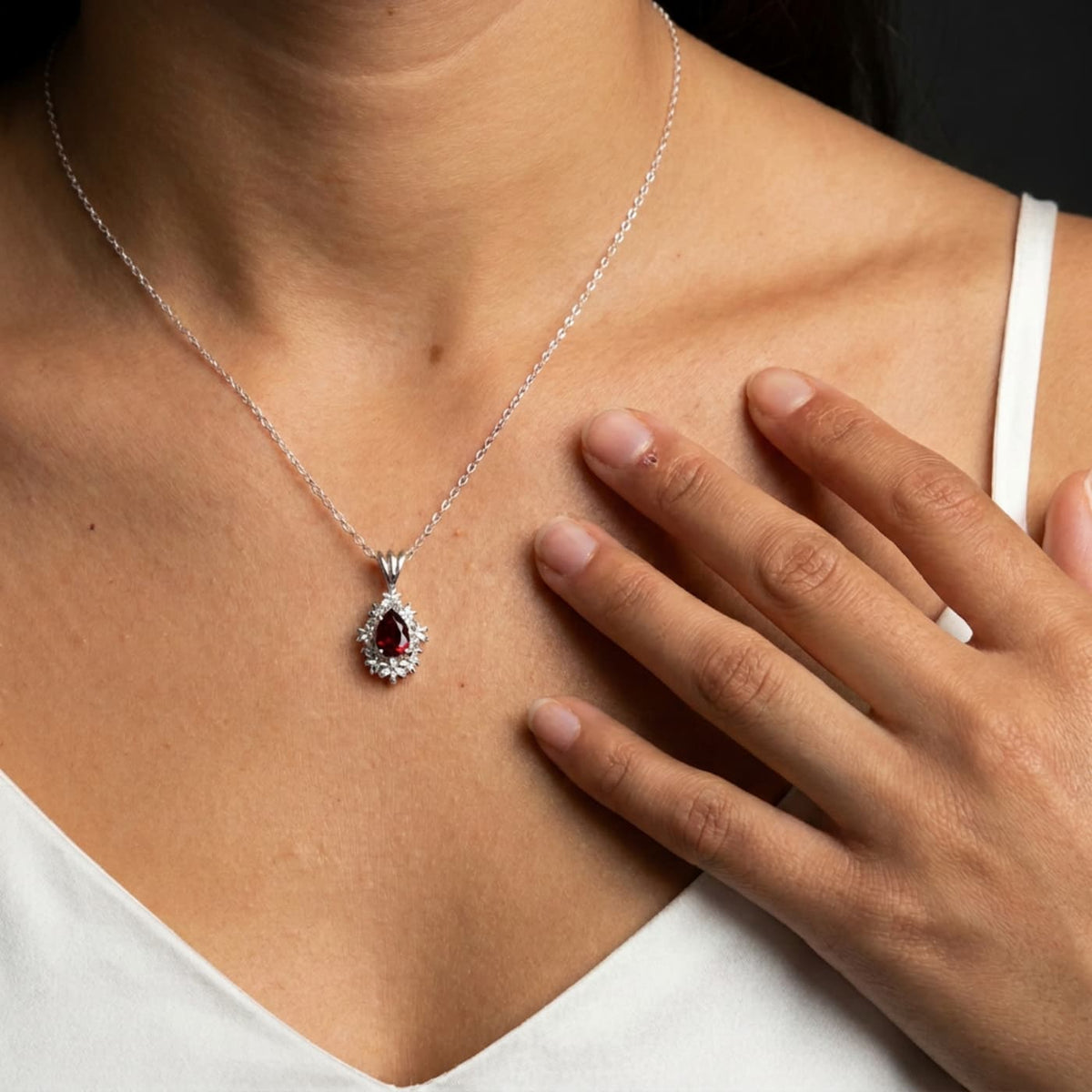 Fleur garnet pendant necklace worn by a model, showing the pear-shaped garnet in recycled sterling silver