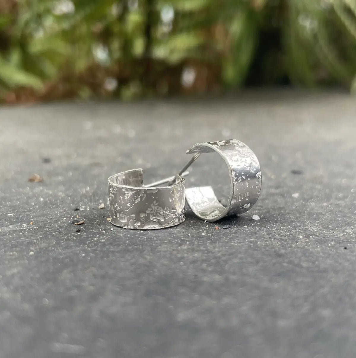 Silver Glitter Hoops in sterling silver — close-up of the lightly textured hoop earrings on slate with ferns in the background