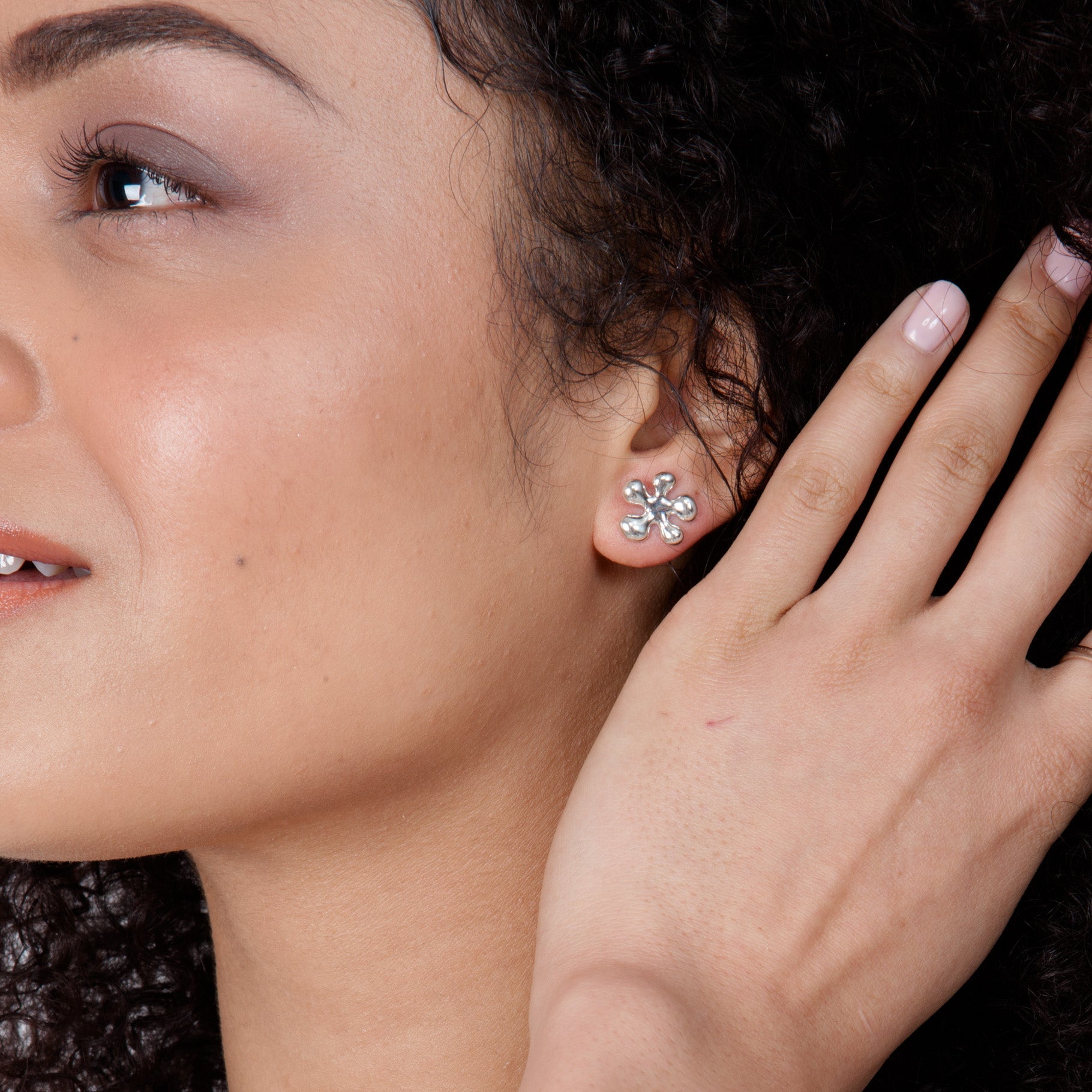 Model wearing the sterling silver Splat earrings, demonstrating the size and playful aesthetic on the ear.