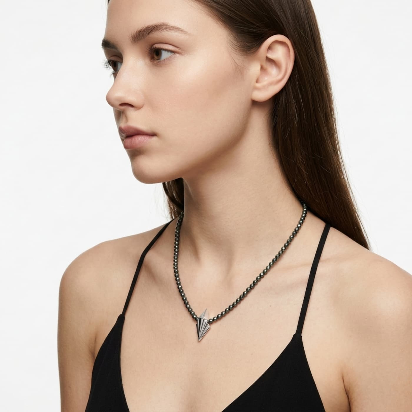 Small Art Deco silver geometric pendant on faceted hematite bead necklace worn on model, showing delicate scale against neckline