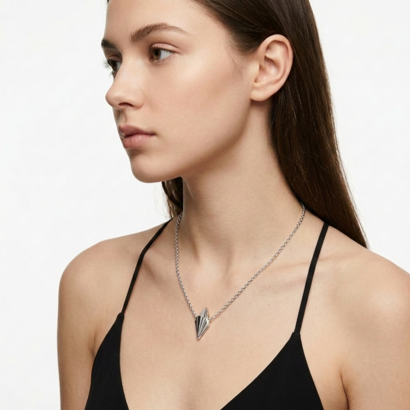 Small Art Deco sterling silver geometric pendant worn on silver chain on model, showing delicate scale against neckline