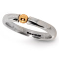 Silver ring with a gold ball on a white background