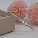 Silver bangle with a gold on a pink floral background