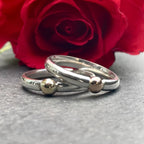 A creative shot of the Solis Original ring nestled within the petals of a rose, emphasizing the warm tones of the 9ct rose gold accent and the ring's elegant design.