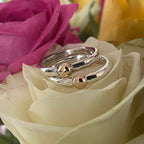 The Solis Original ring in polished recycled silver and 9ct rose and yellow gold sitting on a cream rose