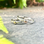 A contemporary lifestyle shot of the Solis Original ring resting on a textured concrete surface, highlighting the contrast between the polished silver and the industrial backdrop.