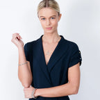 Model wearing a thin sterling silver Splash bangle with a sculptural fluid wave design