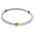 Silver bangle with gold beads on a white background