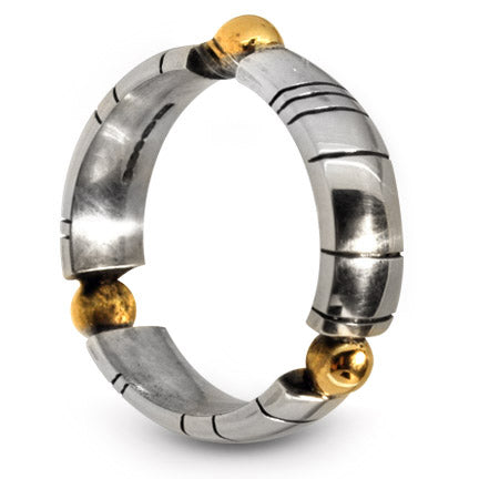 An angled perspective of the Treble Solis ring, showcasing the chunky silver band and the multi-tonal contrast of the three different 9ct gold orbs.