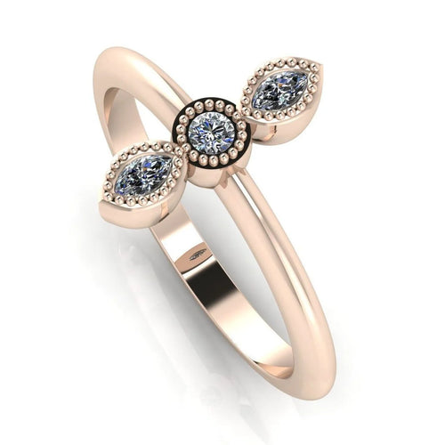 Angled perspective of an 18ct rose gold trilogy diamond ring with fine milgrain textured edges around the settings.