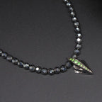 Close-up detail of the green tsavorite garnet and the geometric silver Art Deco setting.