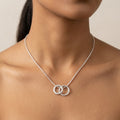 Lifestyle view of the Vanilla Links double silver pendant on a neck chain demonstrating scale and movement.