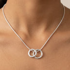 Close up view of the Vanilla Links double silver pendant on a neck chain demonstrating scale and movement.
