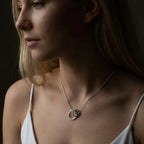 Front view of a model wearing the Vanilla Links Tri Pendant, showing the size and position of the three textured silver links below the collarbone.