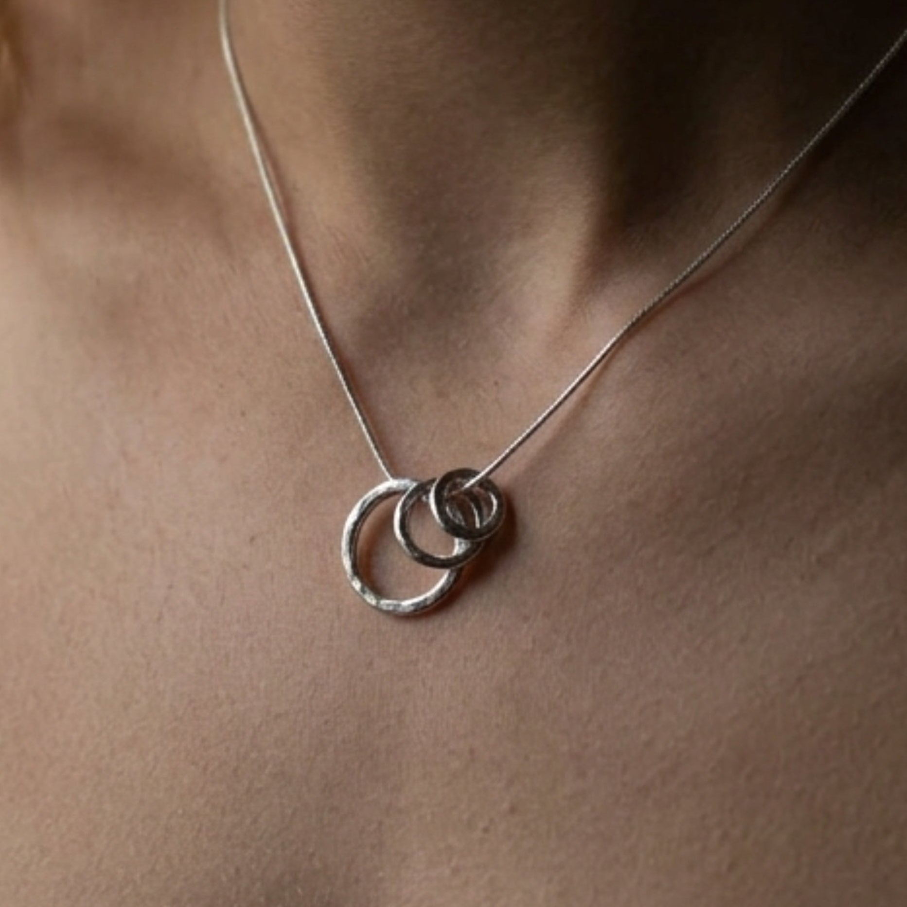 Close up front view of the Vanilla Links Tri-Pendant in sterling silver featuring three interlocking graduated concave discs.