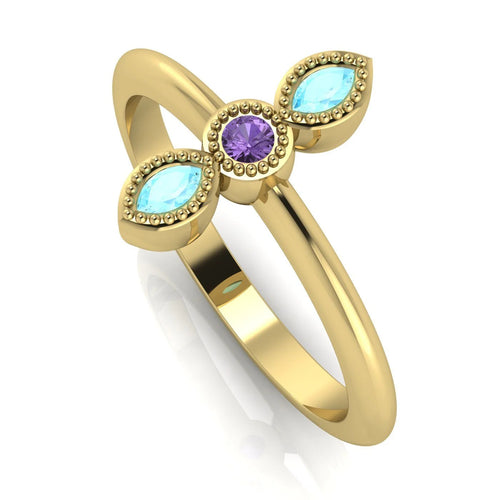Angled view of an 18ct yellow gold trilogy ring featuring a violet sapphire and aquamarines with fine milgrain textures.