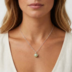Model wearing a white freshwater pearl pendant on a sterling silver chain by Nude Jewellery.