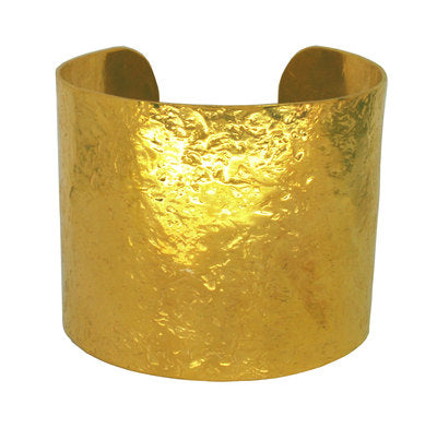 Wide statement gold cuff bracelet on a white background