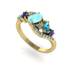 Side profile of the yellow gold Atlantis Storm ring, highlighting the wave setting and the blue gemstone cluster.