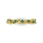 Top-down studio hero shot of the yellow gold alternative eternity ring, showcasing the unique linked bubble design precisely flush-set with green emeralds and yellow sapphires.